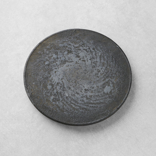 Round tea tray in dark mottled lacquer, its surface swirling like weathered stone.