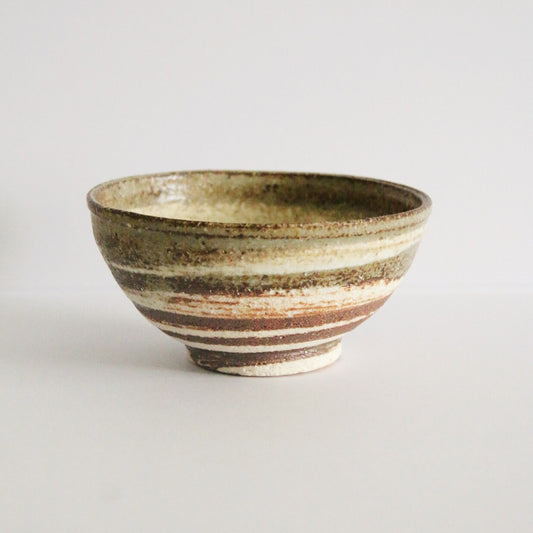 Footed rice bowl banded in cream and rust-brown brushed slip with a dark rim.