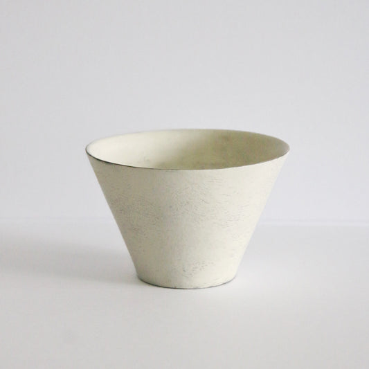 Wide conical cream cup flaring sharply from a narrow base, with a chalky matte surface.