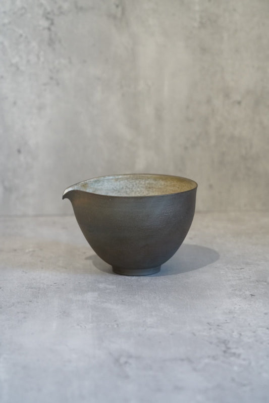Small grey pouring bowl with a drawn lip and a pale sea-green glazed interior.