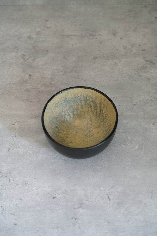Small wooden bowl with a black outer wall and a mottled sage green lacquered interior.