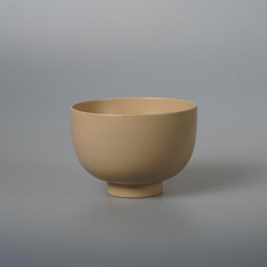 Deep footed wooden bowl in soft matte cream lacquer, its curve rising to a thin rim.