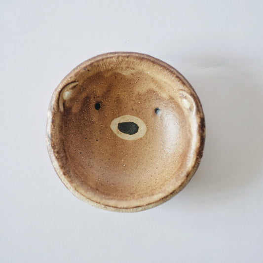 Shallow bowl glazed in warm caramel and modelled as a bear's face, with small ears at the rim.