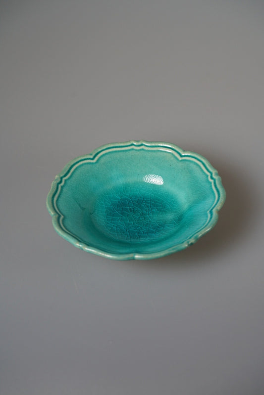 Shallow plate with a softly scalloped rim in vivid turquoise green glaze.