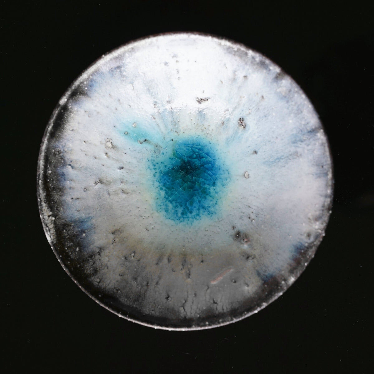 Shallow wood-fired bowl in mottled white and grey with a vivid turquoise pool at its centre.