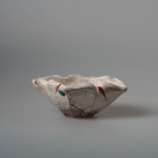 Low bowl with a folded, wave-like rim, painted with small red and green marks.