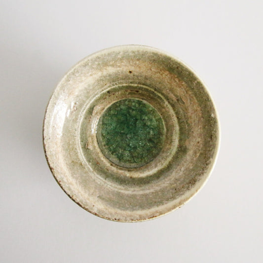 Cream bowl seen from above with a broad ring of jade green glaze pooling in its well.