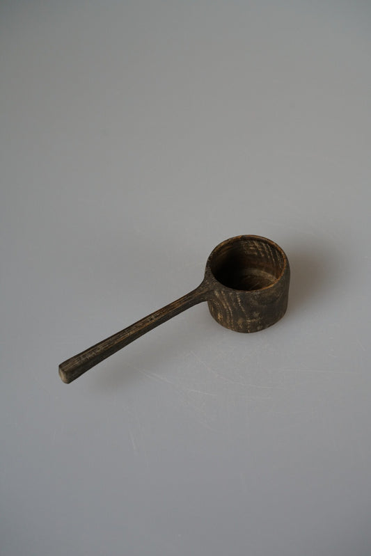 Long-handled wooden scoop with a deep round bowl, finished in dark brown lacquer.
