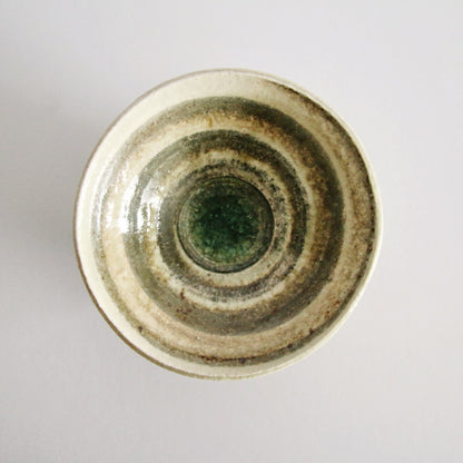Cream bowl seen from above, banded in soft olive rings around a jade green centre.