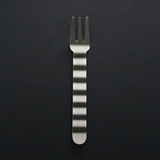 Stainless steel dinner fork with a hand-hammered handle banded in bright and matte stripes, on black.
