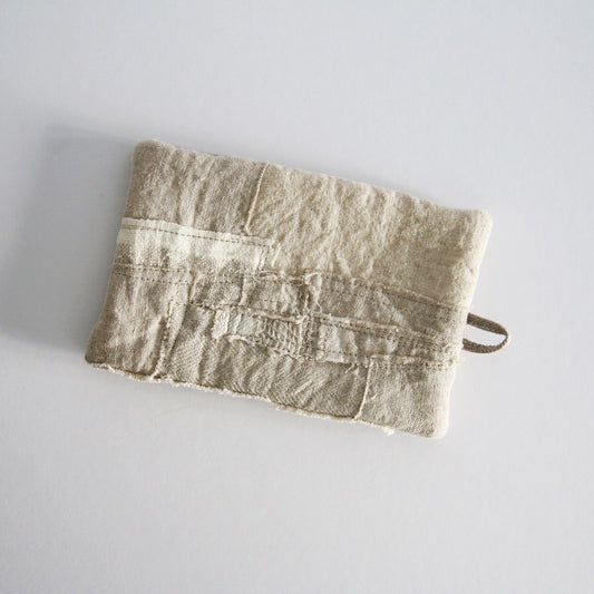 Small patchwork tea mat in undyed linen, its panels stitched in soft cream and oatmeal.