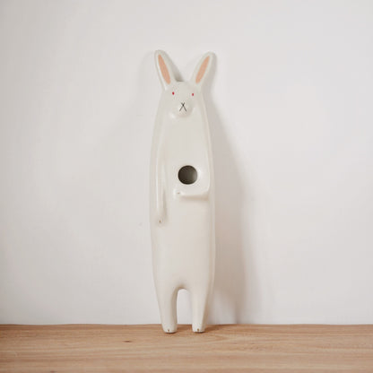 Tall standing ceramic rabbit in white with a round opening in its belly to hold a flower.