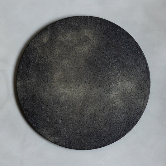 Large round tray in deep matte black with a soft, faintly clouded lacquer surface.