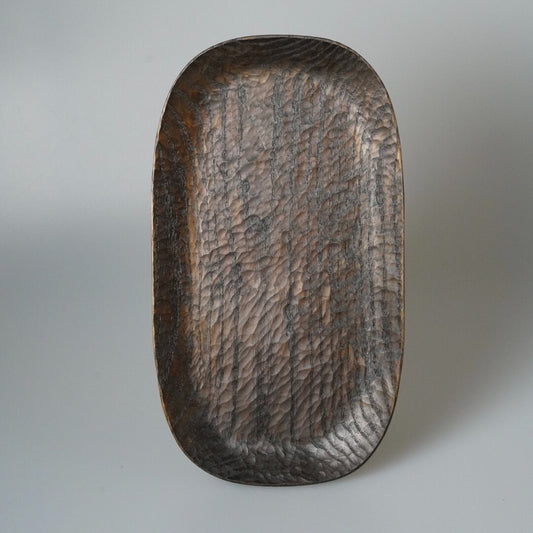 Oval wooden tray carved all over in fine chisel marks, finished in deep warm brown.