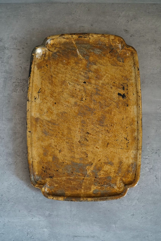 Rectangular tray with raised corners, its surface a mottled gold and rust lacquer over black.