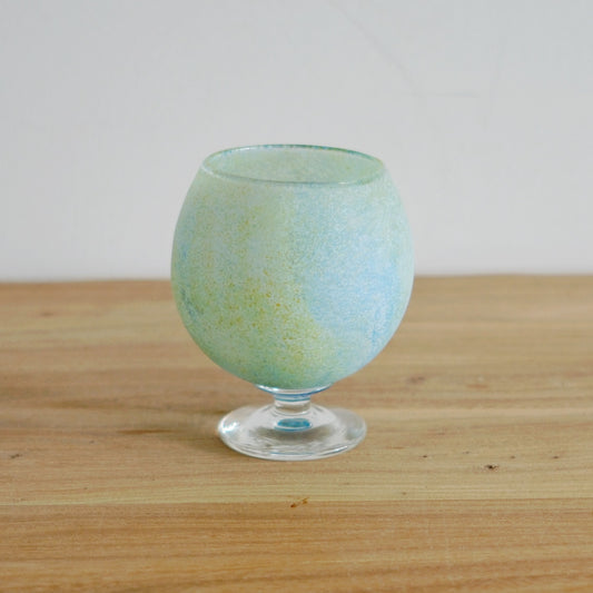 Footed glass goblet graded from pale green to soft blue, with a frosted speckled surface.