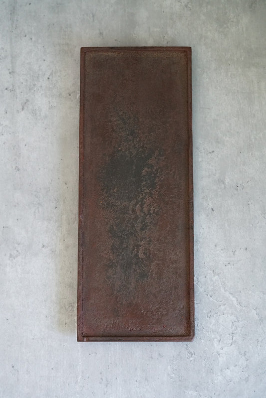 Long rectangular tray in deep red-brown lacquer with a softly clouded, weathered surface.