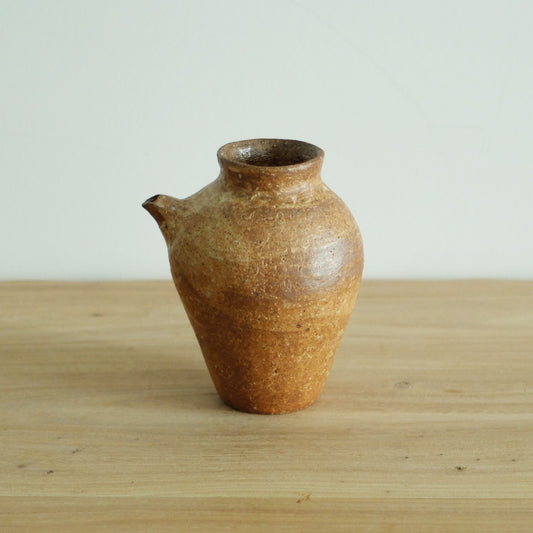 Wood-fired jug with a full belly, drawn spout and narrow neck, in sandy orange-brown.
