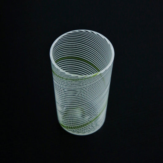 Tall clear glass tumbler wrapped in fine horizontal lines with a thin green thread running through.