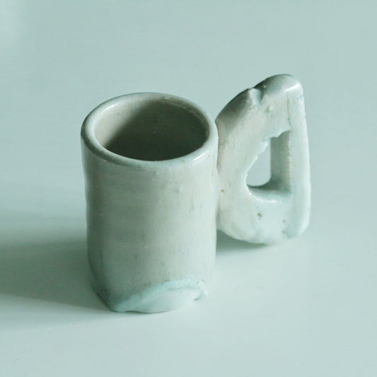 Small cream mug with a soft blue base and an oversized rounded loop handle.
