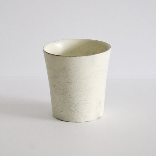 Small cream cup with gently sloping sides and a soft chalky surface, on white.
