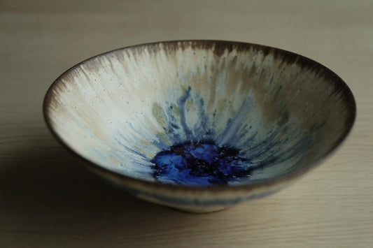 Wide shallow tea bowl, cream and olive glaze streaming down the sides to a deep blue pool at the centre.