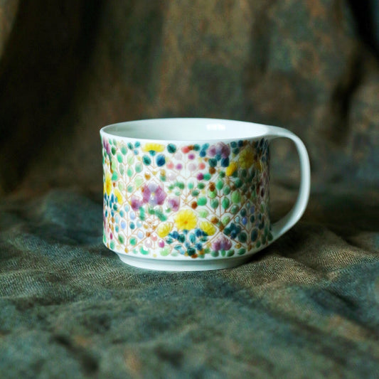 White porcelain mug scattered all over with tiny hand-painted blossoms in many colours.