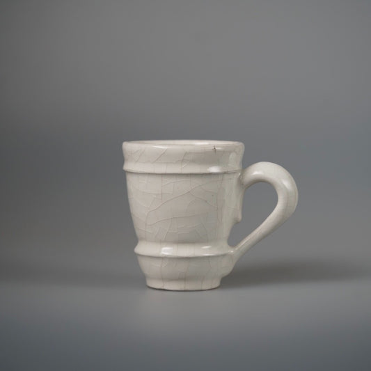 Tall cream mug with a stepped ribbed body, a chalky glaze and a large curved handle.