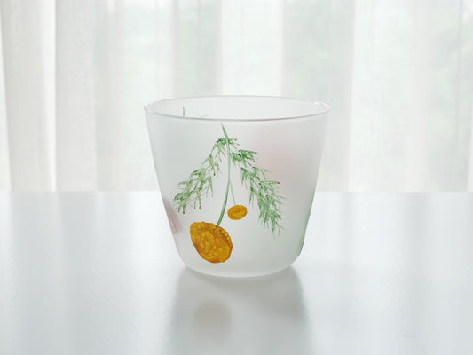 Frosted white glass cup painted with a single yellow bloom on a slender green stem.