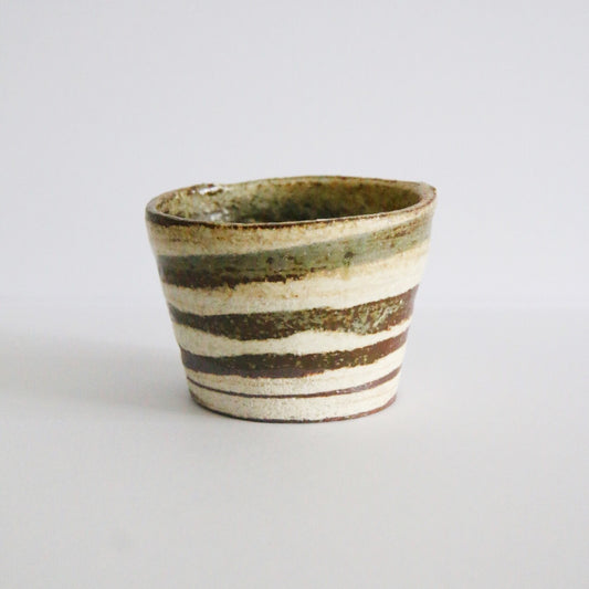Small flared cup ringed with alternating cream and rust-brown bands of brushed slip.
