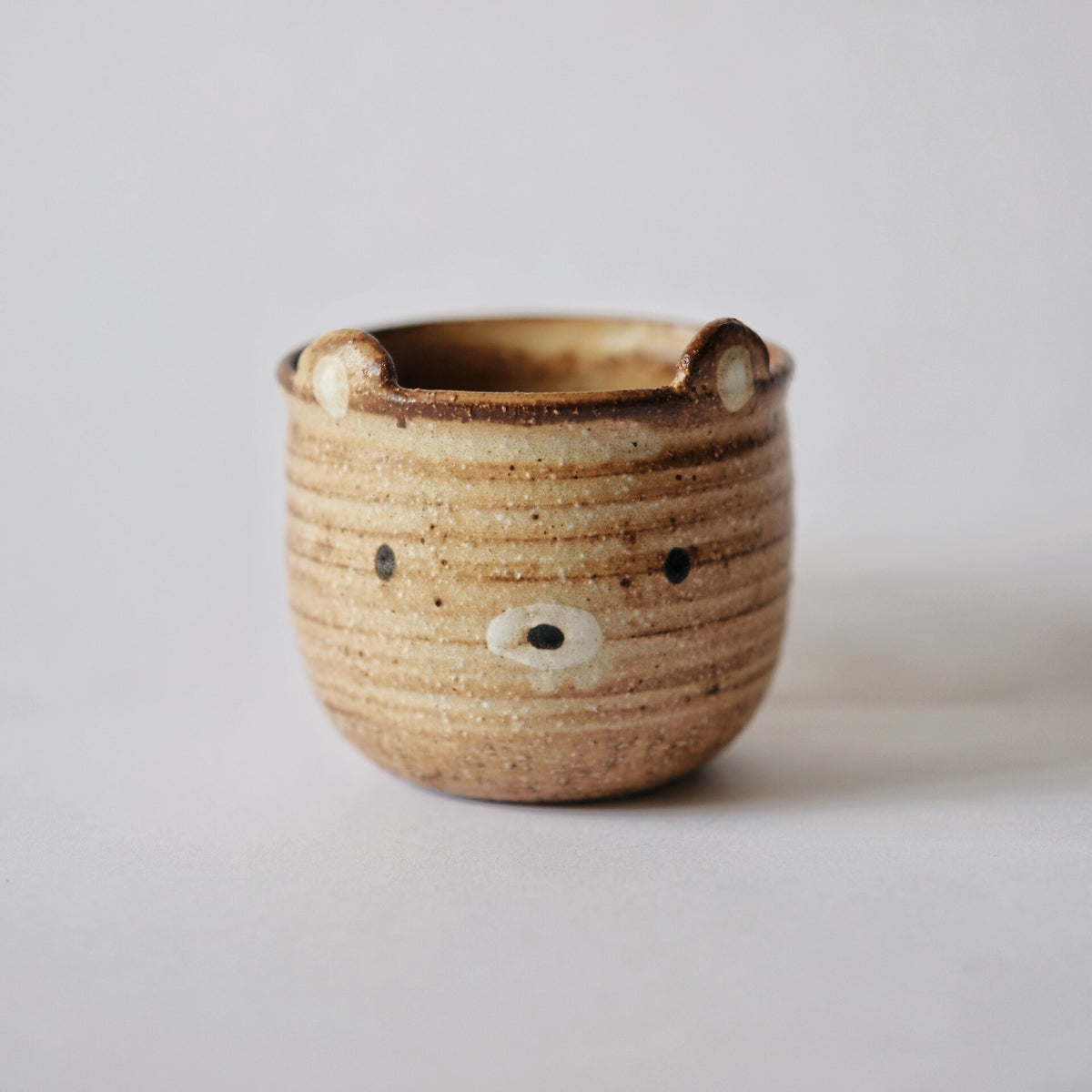Ribbed caramel mug modelled as a bear, with small ears at the rim and a painted face.