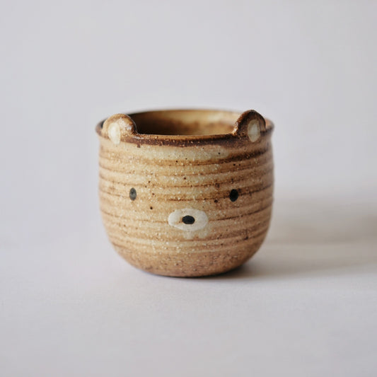 Ribbed caramel mug modelled as a bear, with small ears at the rim and a painted face.