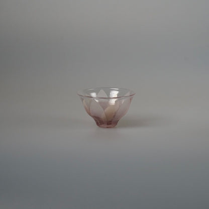 Small flared glass tea cup in dusty pink and lilac with a softly petalled rim.