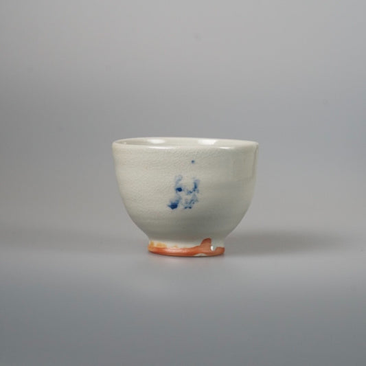 White tea bowl with a finely crackled glaze, a small blue underglaze mark and an unglazed orange foot ring.
