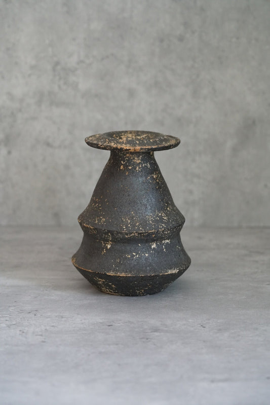 Stepped conical vase in dark charcoal with a wide flat lip and gold flecks in the surface.