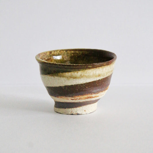 Footed cup with broad bands of olive, rust and cream slip and a dark green glazed interior.