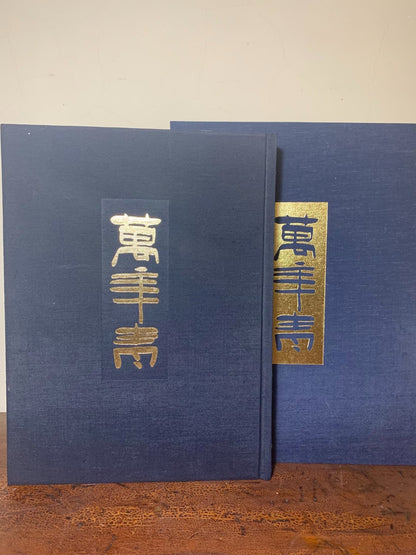 Two dark blue cloth-bound books with vertical gold foil characters on their spines.