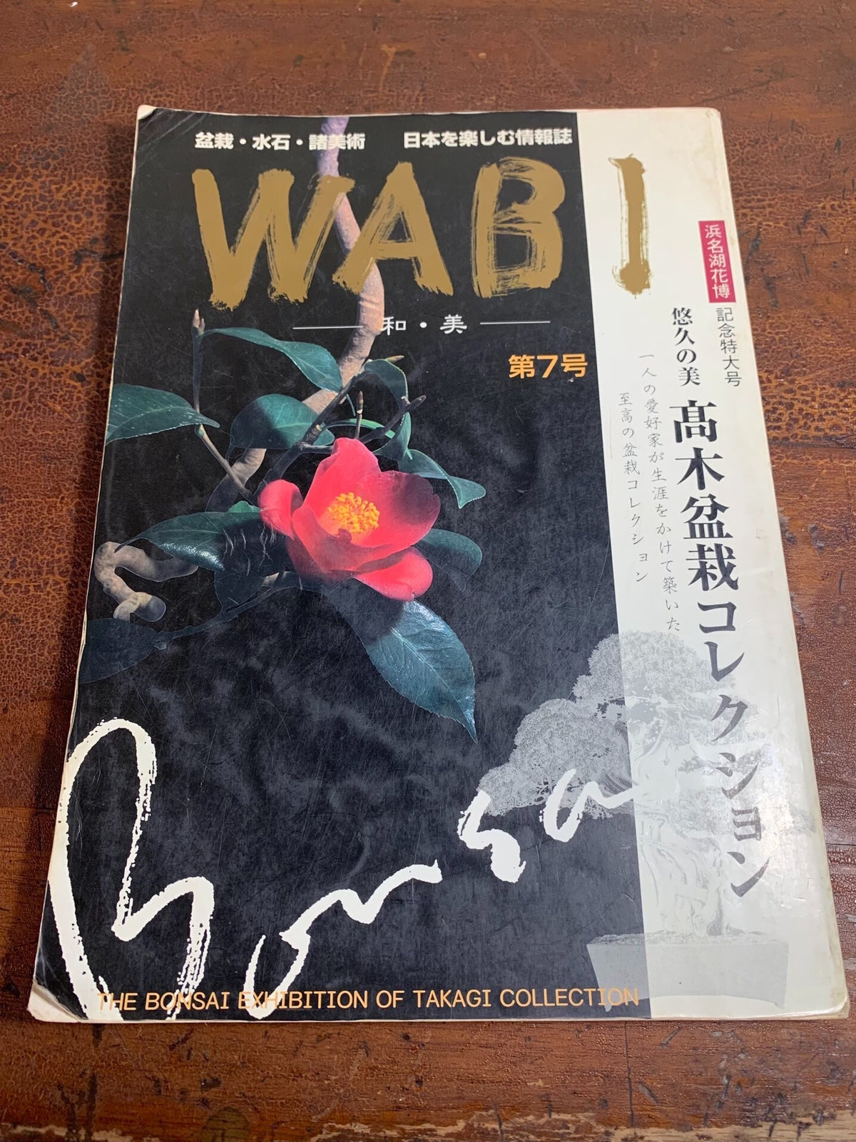 A black magazine cover with gold "WABI" text, a red flower, and Japanese characters.