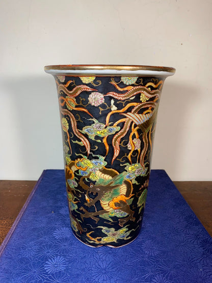 A tall, dark blue glazed pot with gold and multi-colored dragon motifs on its surface.