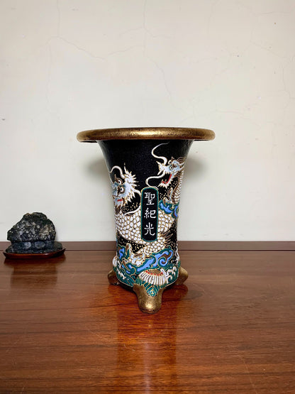 Black glazed pot with gold rim and three dragons, one holding a plaque with characters.