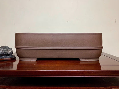 A matte brown rectangular pot with a textured surface and a single horizontal ridge.