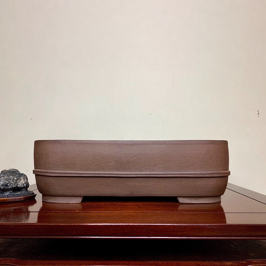 A matte brown rectangular pot with a textured surface and a single horizontal ridge.