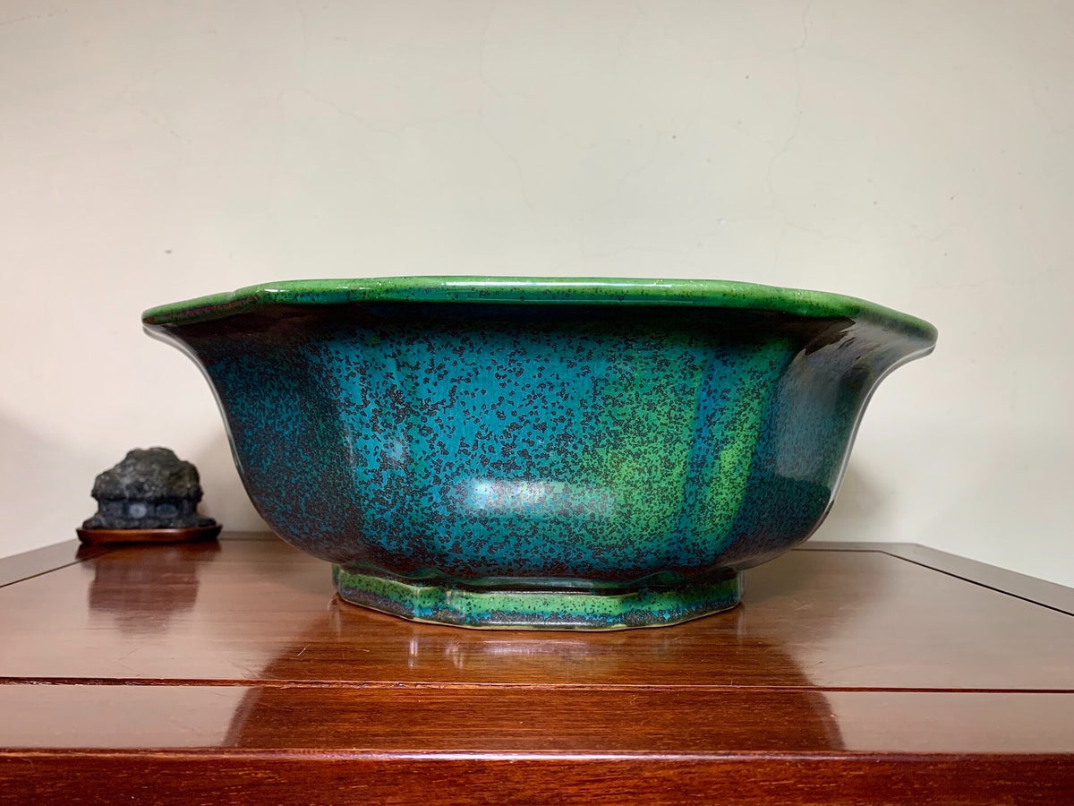 A wide, shallow ceramic pot with a glossy, speckled teal and green glaze.