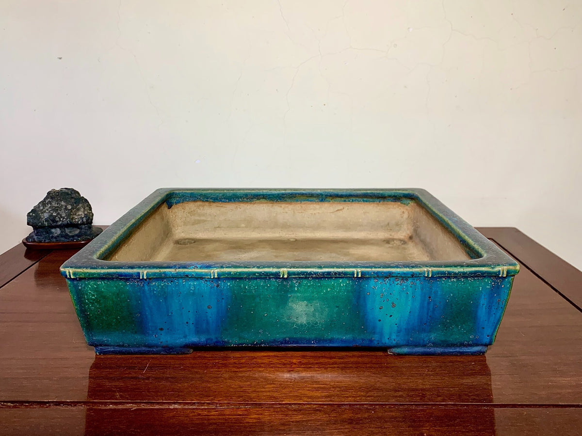 Rectangular glazed ceramic pot with blue-green gradient and speckled rim, unglazed beige interior.