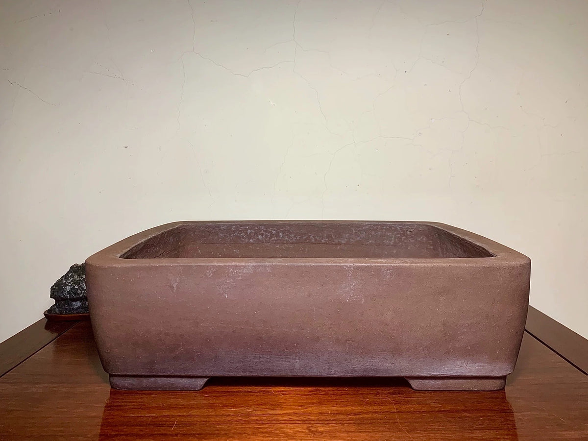 Rectangular brown unglazed ceramic pot with rounded corners and matte finish.
