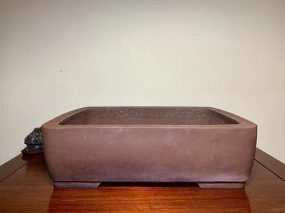Rectangular brown unglazed ceramic pot with rounded corners and matte finish.