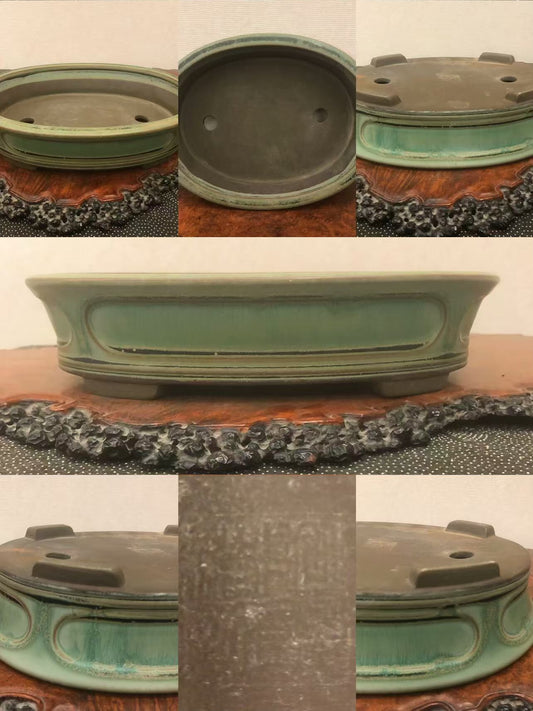 A green glazed oval bonsai pot with a textured surface and drainage holes.