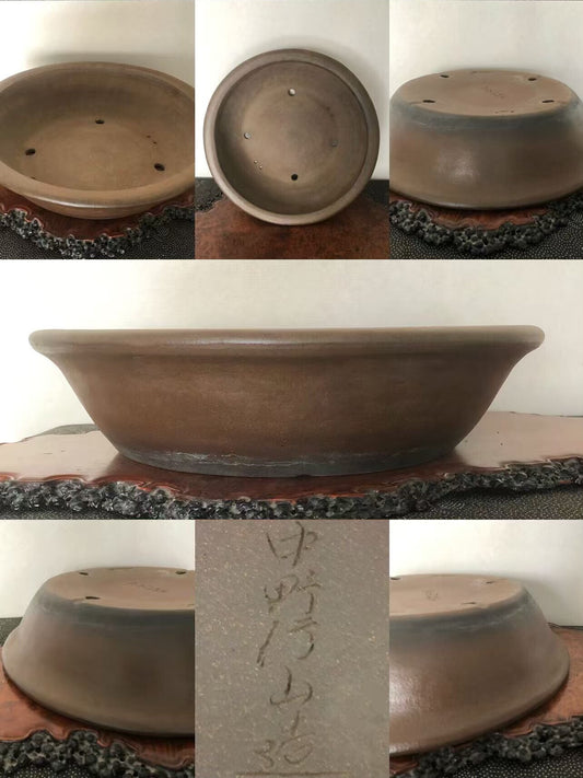 A brown glazed ceramic bonsai pot with a wide rim and three drainage holes.