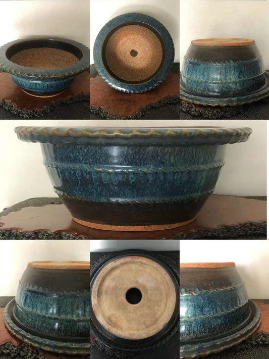 A glazed blue ceramic pot with a scalloped rim and textured surface.