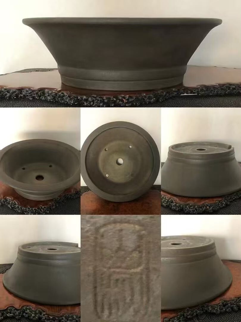 Dark grey unglazed ceramic pot, wide rim, central hole, with carved seal mark.